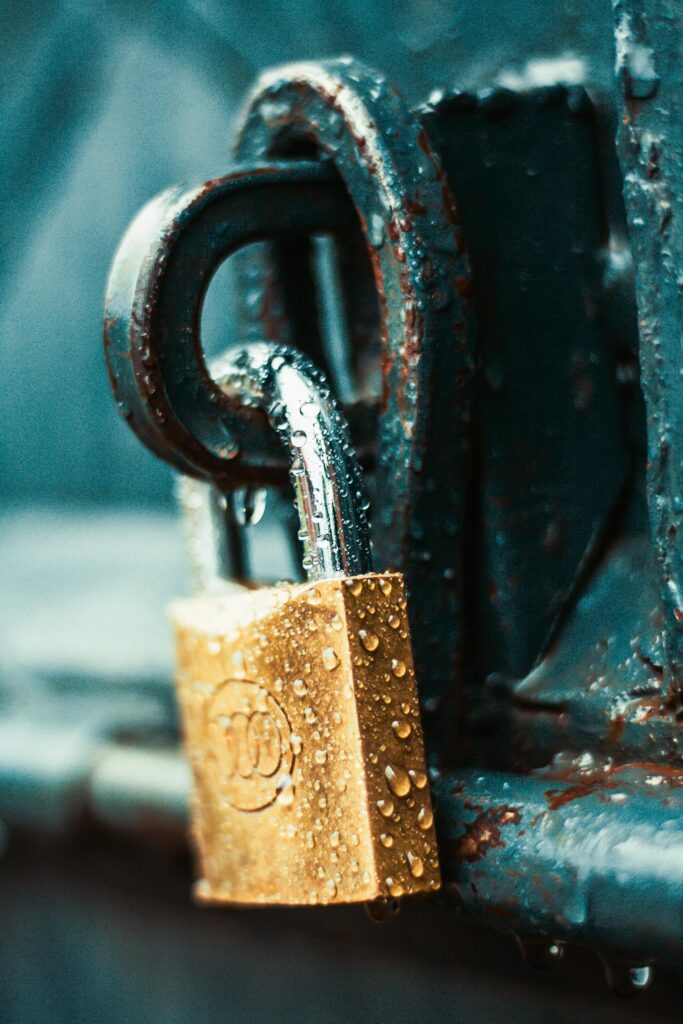 A detailed shot of a wet padlock on a rusty metal surface, showcasing textures and water droplets.